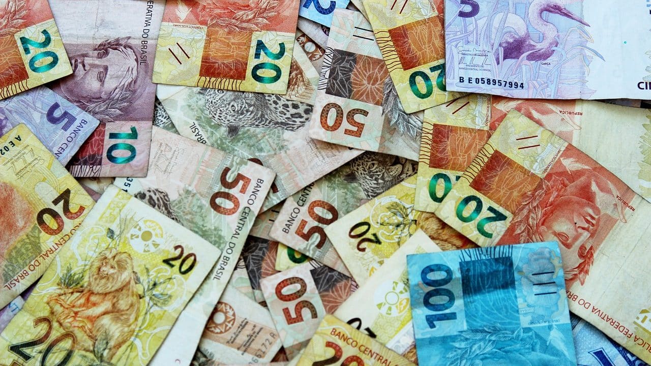 Imagem mostra dinheiro sendo investido em CDB pós-fixado
