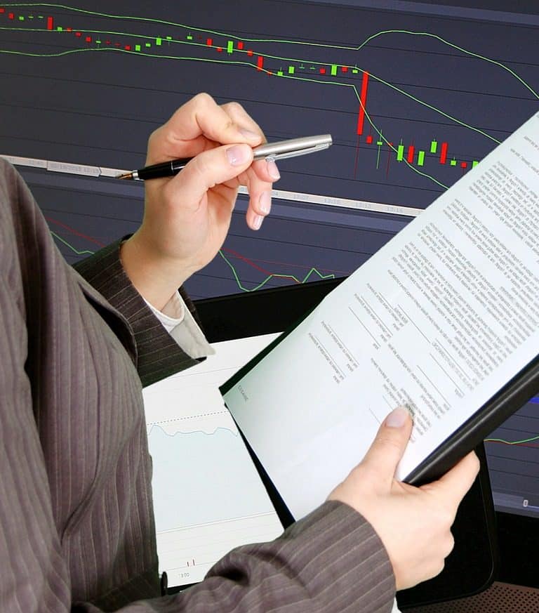 Imagem mostra investidora analisando o tripé dos investimentos