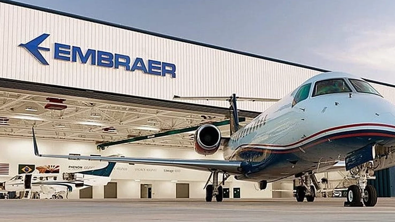Imagem mostra avião e logo da Embraer (EMBR3)