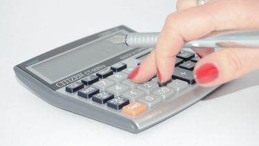 Imagem mostra mulher calculando a taxa de corretagem